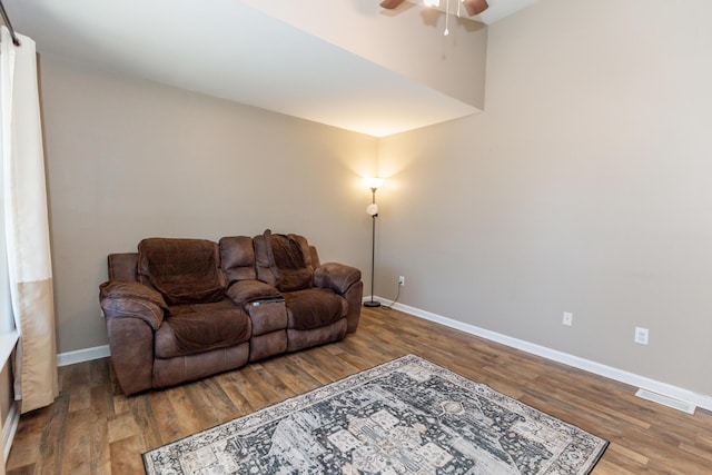 living room with visible vents, wood finished floors, a ceiling fan, and baseboards