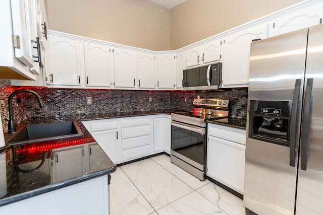 kitchen featuring appliances with stainless steel finishes, a sink, and white cabinets