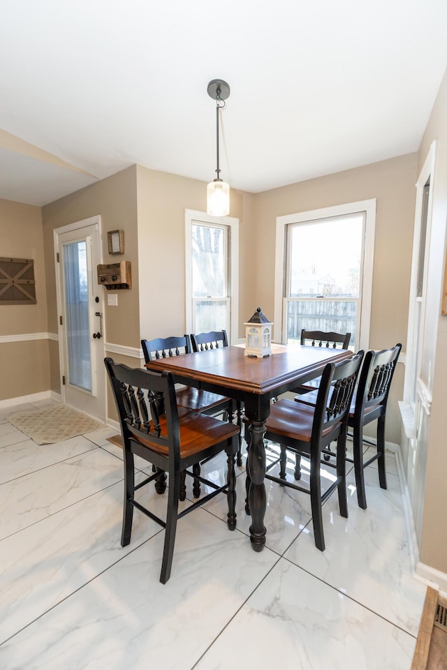 dining space with marble finish floor and baseboards