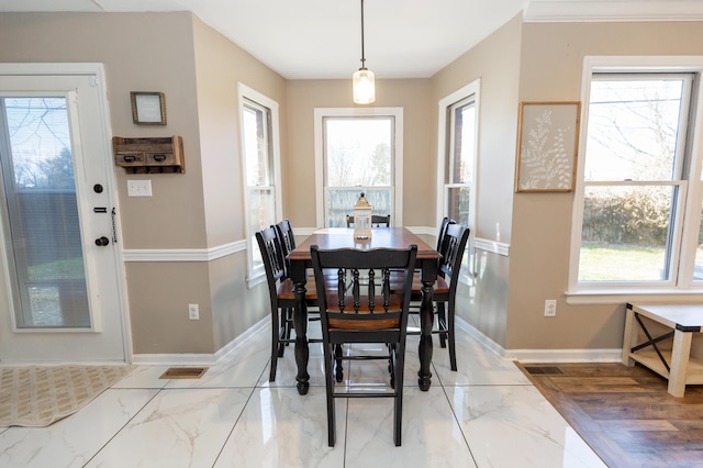 dining area with marble finish floor, plenty of natural light, and baseboards