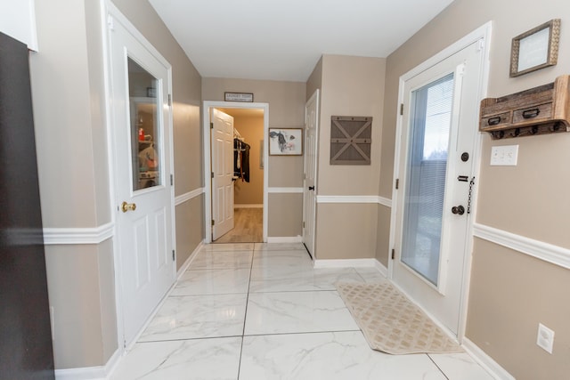 hall featuring marble finish floor and baseboards