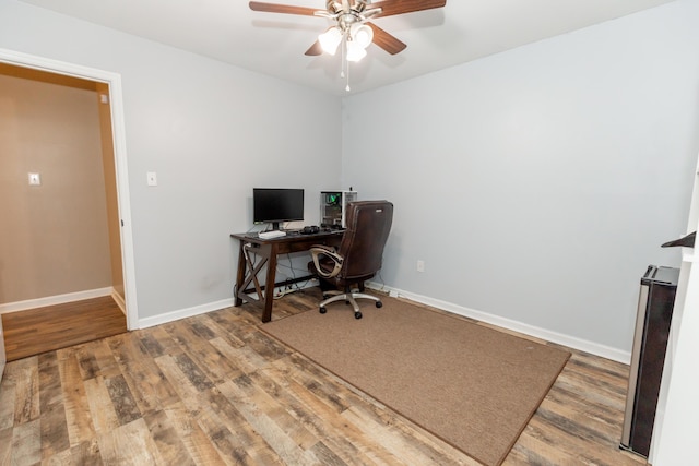 office featuring ceiling fan, baseboards, and wood finished floors