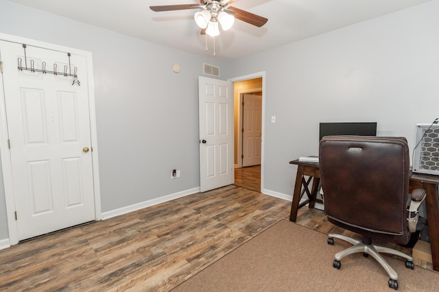 office with a ceiling fan, wood finished floors, visible vents, and baseboards