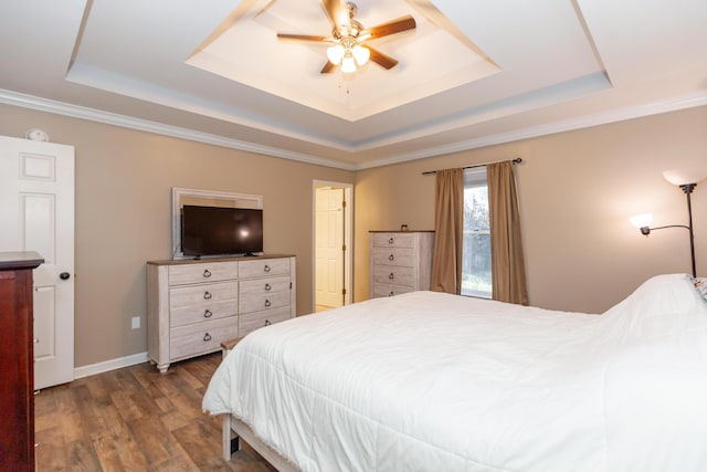 bedroom featuring ceiling fan, dark wood-type flooring, a raised ceiling, and baseboards