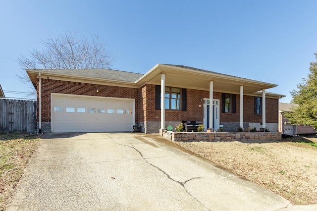 ranch-style home featuring brick siding, covered porch, fence, a garage, and driveway