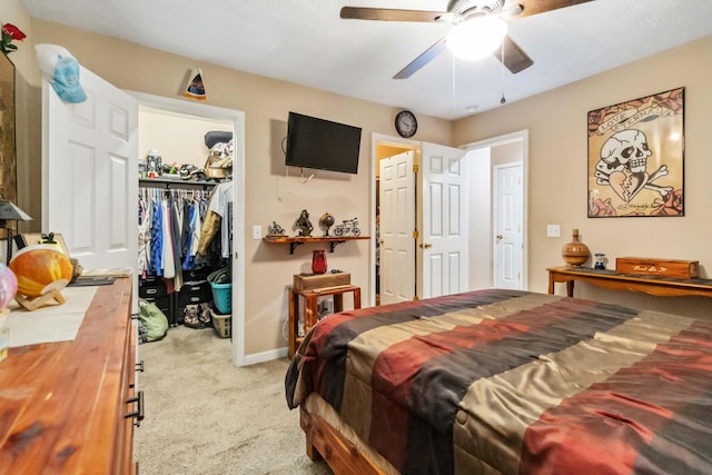 carpeted bedroom with ceiling fan, a spacious closet, and a closet