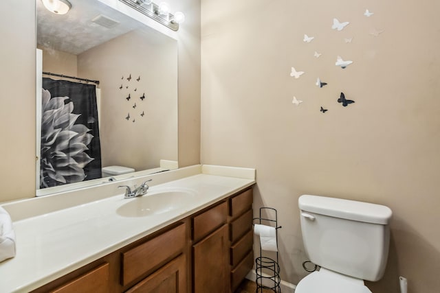 bathroom featuring vanity, toilet, and a shower with shower curtain