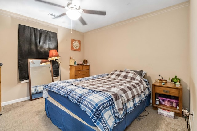 carpeted bedroom with ornamental molding and ceiling fan