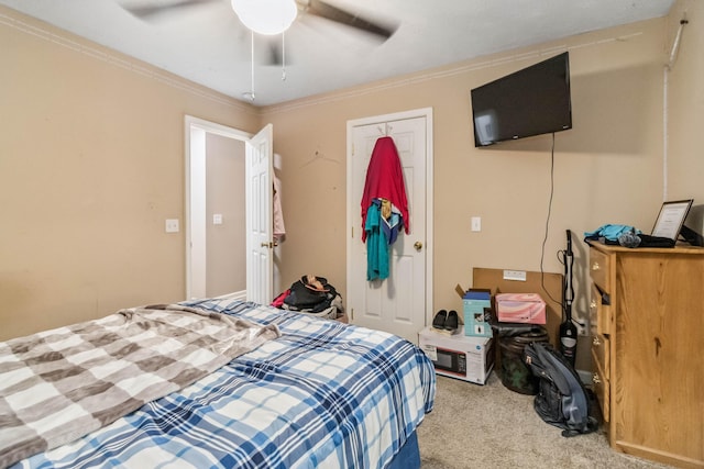 carpeted bedroom with crown molding and ceiling fan