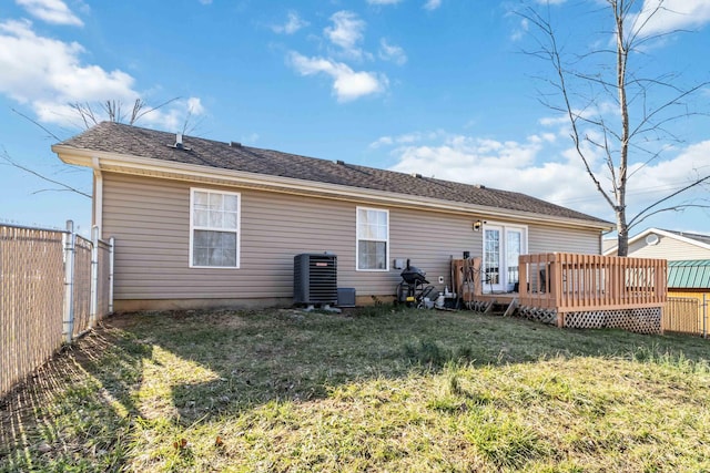 rear view of house with central AC unit, a yard, and a deck