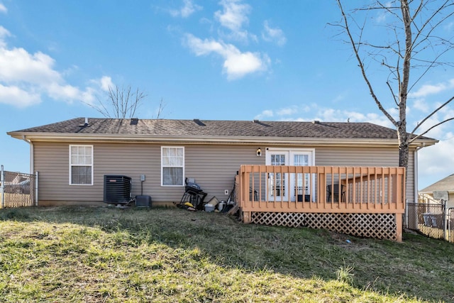 rear view of property with cooling unit, a deck, and a lawn