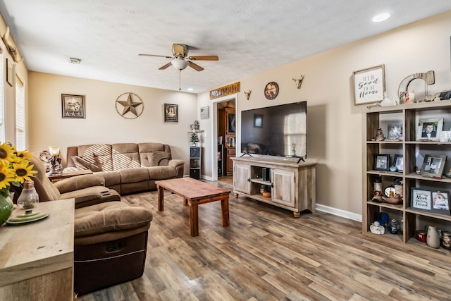 living room with wood-type flooring, a textured ceiling, and ceiling fan