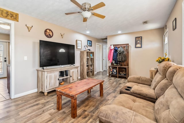 living room featuring plenty of natural light, ceiling fan, and light wood-type flooring