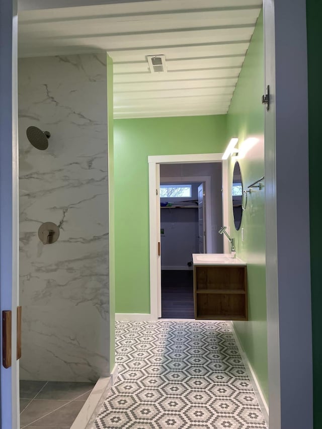 bathroom featuring vanity, tile patterned floors, and a shower