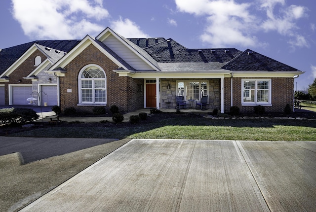 single story home with a garage, covered porch, and a front lawn