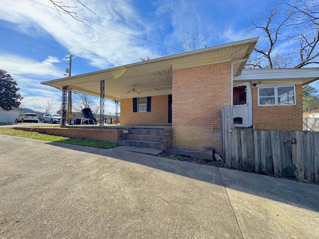 view of property exterior with a ceiling fan, brick siding, and covered porch