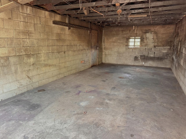 below grade area featuring a garage and concrete block wall