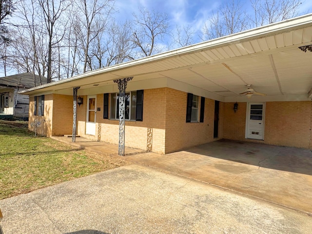 view of front of property featuring ceiling fan, a front yard, and a carport