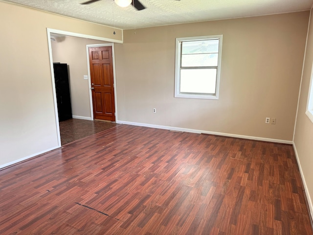 unfurnished room with a textured ceiling, baseboards, wood finished floors, and a ceiling fan