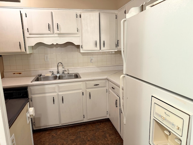 kitchen with freestanding refrigerator, light countertops, white cabinetry, and a sink