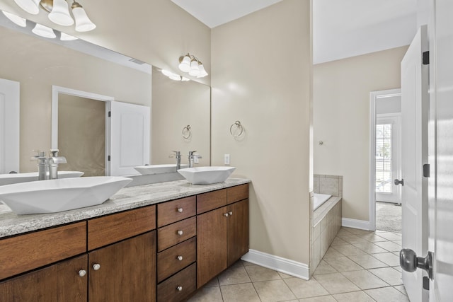 bathroom featuring vanity, tiled tub, and tile patterned flooring