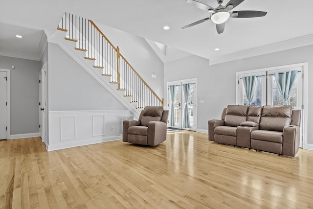 unfurnished living room with ceiling fan, ornamental molding, and light wood-type flooring