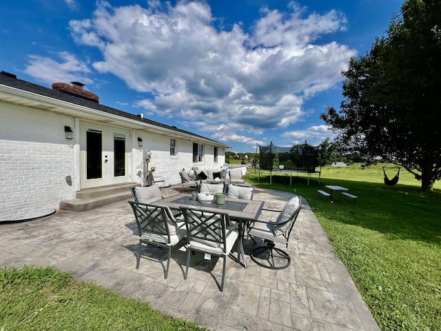 view of patio / terrace with outdoor dining area, french doors, and a trampoline