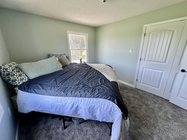 bedroom featuring baseboards, carpet floors, and a textured ceiling