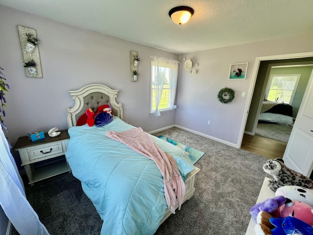 bedroom featuring carpet, baseboards, and a textured ceiling