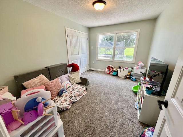 rec room featuring carpet, baseboards, and a textured ceiling