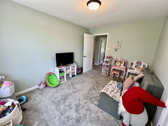 playroom featuring baseboards, carpet floors, and a textured ceiling