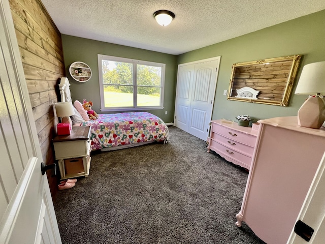 carpeted bedroom with a closet and a textured ceiling