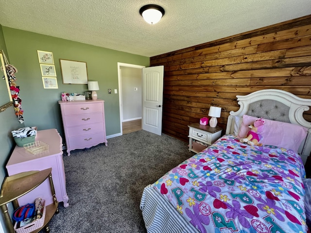 bedroom featuring wood walls, carpet flooring, and a textured ceiling