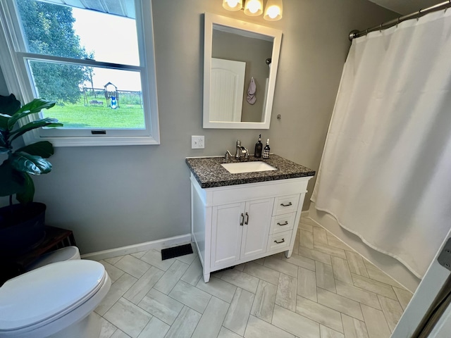 bathroom with baseboards, toilet, and vanity