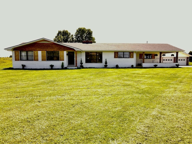 ranch-style house featuring a chimney, a front yard, and an attached garage