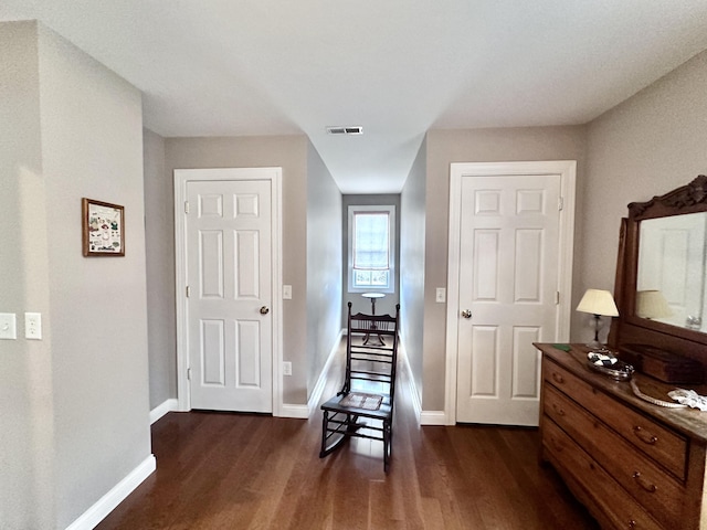 living area with dark wood-style floors, visible vents, and baseboards