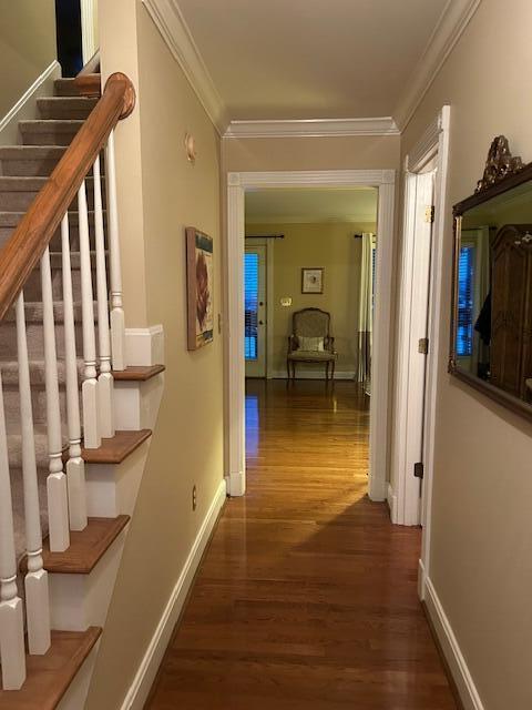 corridor with ornamental molding and dark hardwood / wood-style floors