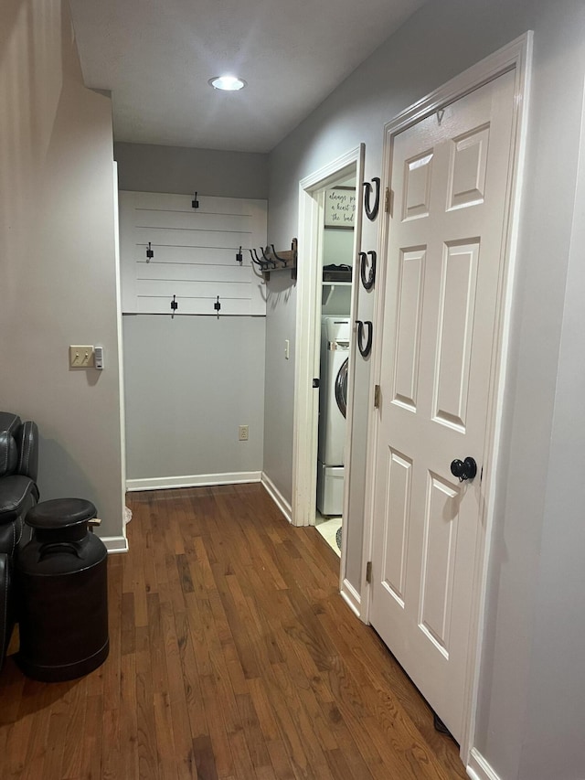 hallway with baseboards, washer / clothes dryer, and dark wood-style flooring