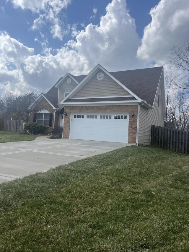 view of front of property with driveway, fence, a front yard, a garage, and brick siding