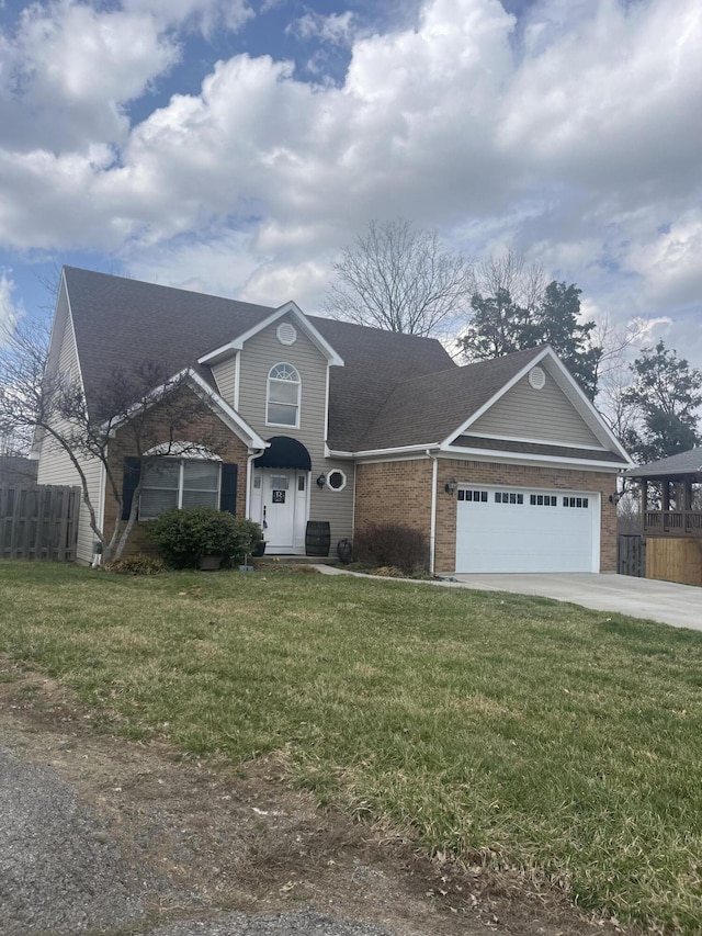 view of front of house with brick siding, a garage, a front yard, and fence