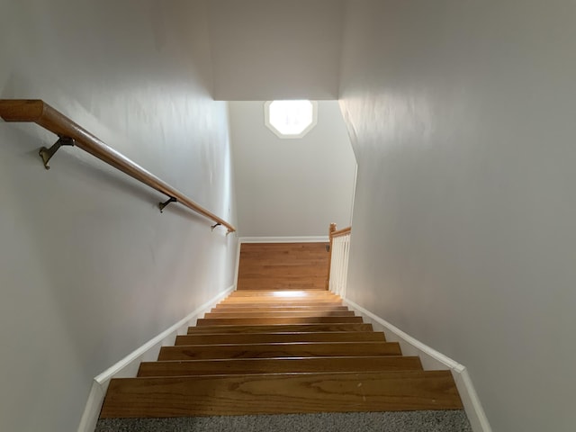 staircase with wood finished floors and baseboards