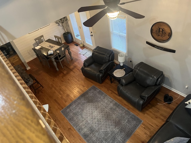 living room with a ceiling fan, wood finished floors, and baseboards