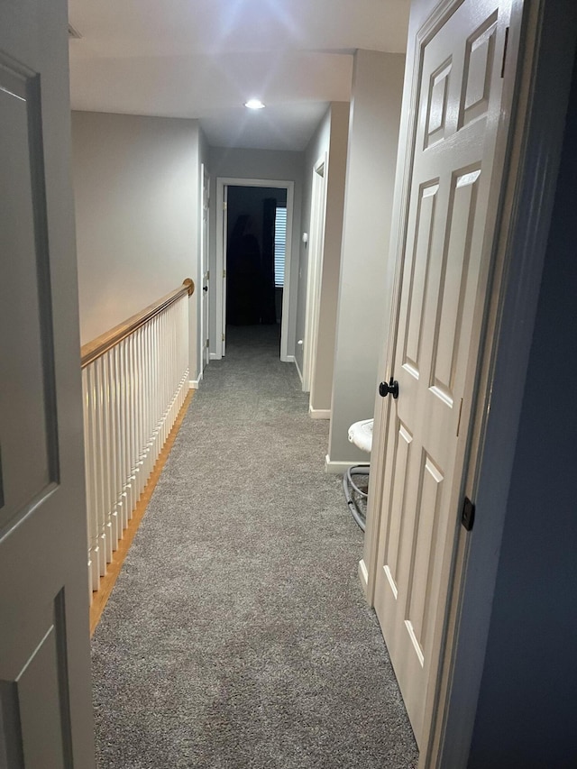 corridor with baseboards and light carpet