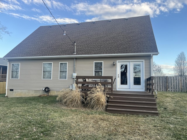 back of house featuring a lawn, fence, and roof with shingles