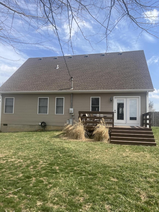 rear view of property featuring a yard, a wooden deck, and a shingled roof