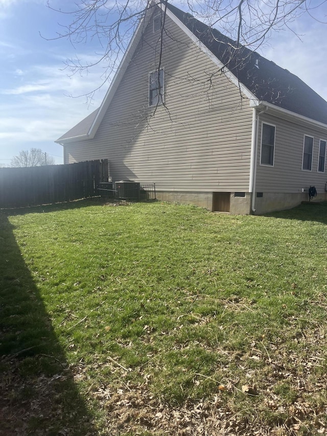 view of side of home featuring crawl space, a yard, and fence