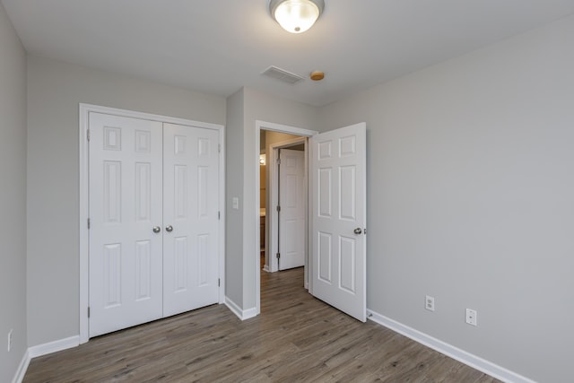 unfurnished bedroom featuring light wood-type flooring and a closet