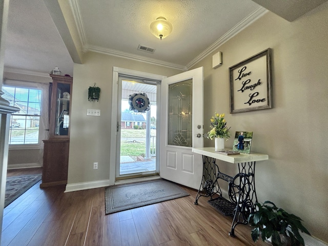 entrance foyer with hardwood / wood-style flooring, ornamental molding, and a textured ceiling