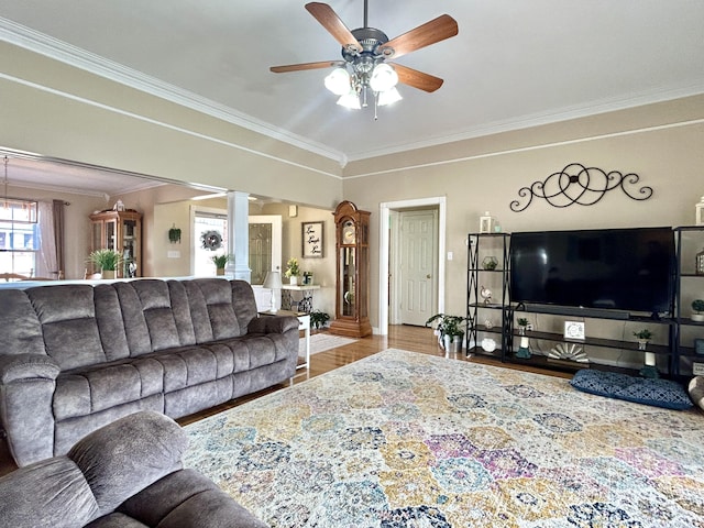 living room featuring ornate columns, crown molding, ceiling fan, and light wood-type flooring