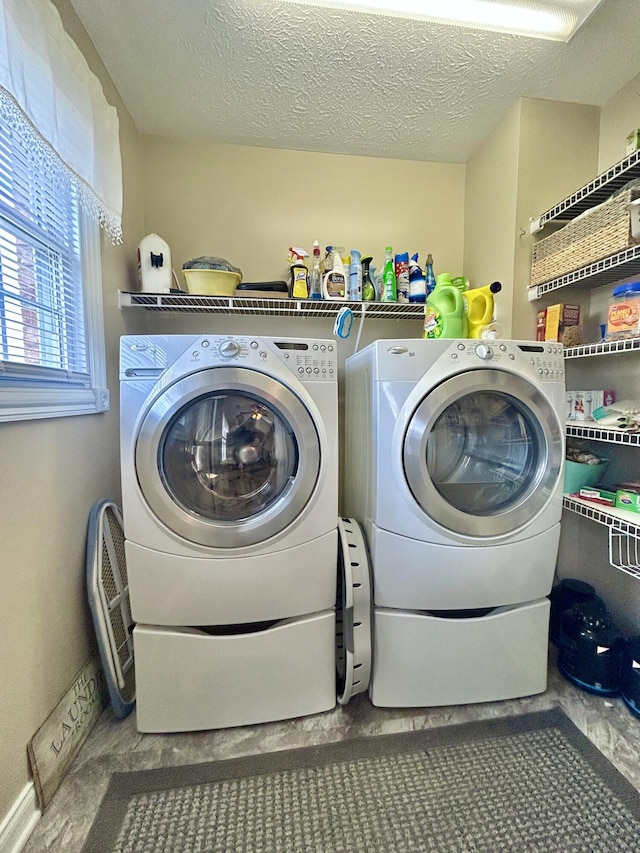 laundry area with washer and dryer and a textured ceiling